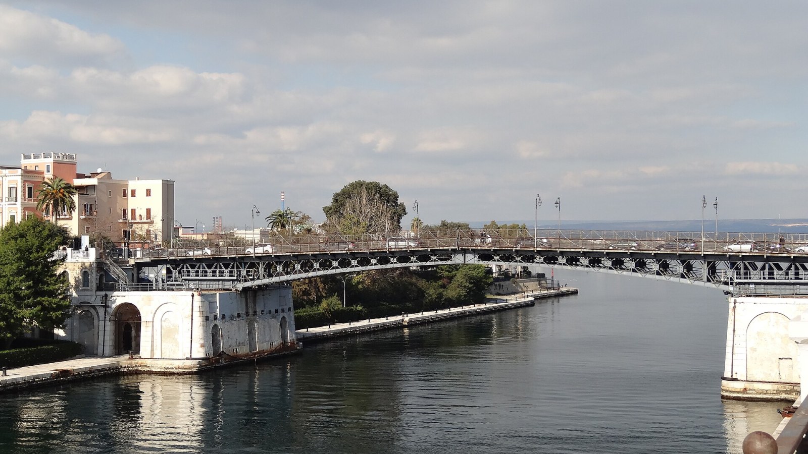 Vista aerea del Mar Piccolo di Taranto all'ora d'oro, con i cerchi concentrici dei citri visibili in superficie e i pali degli allevamenti di mitili