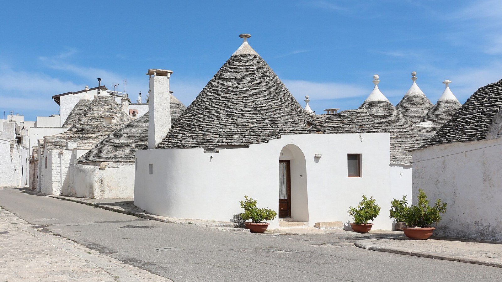 I trulli del Rione Monti di Alberobello al tramonto, con i caratteristici tetti conici in pietra calcarea illuminati dalla luce dorata