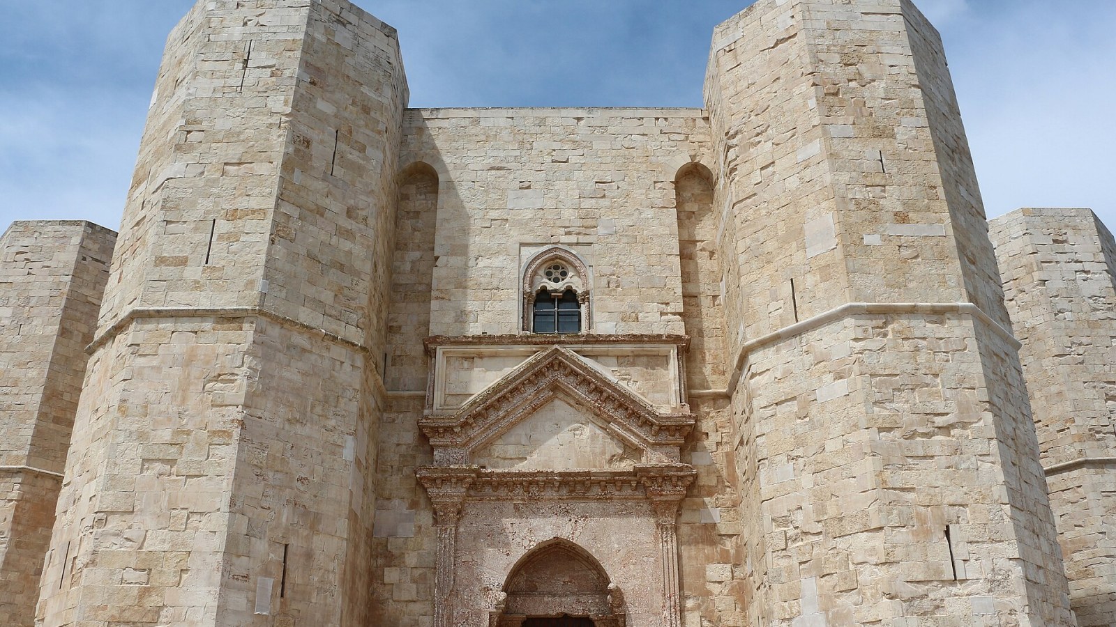 Castel del Monte visto dall'alto al tramonto, con le ombre geometriche delle torri ottagonali sul cortile interno
