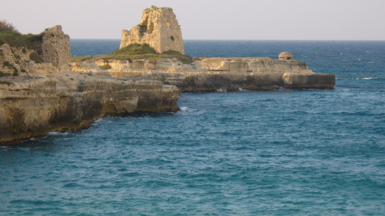 La scogliera calcarea di Roca Vecchia a Melendugno, nel Salento, con la costa adriatica e l'ingresso della Grotta della Poesia
