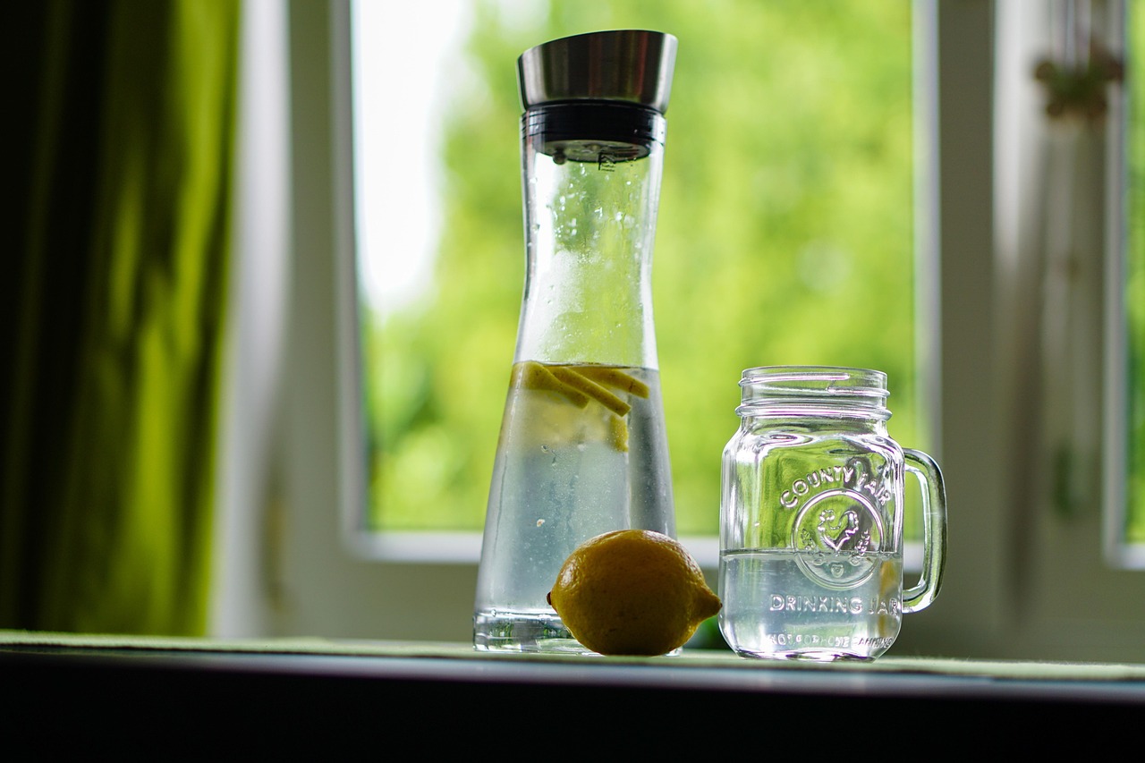 Un bicchiere di acqua con limone fresco, simbolo di salute e benessere per fegato e digestione.