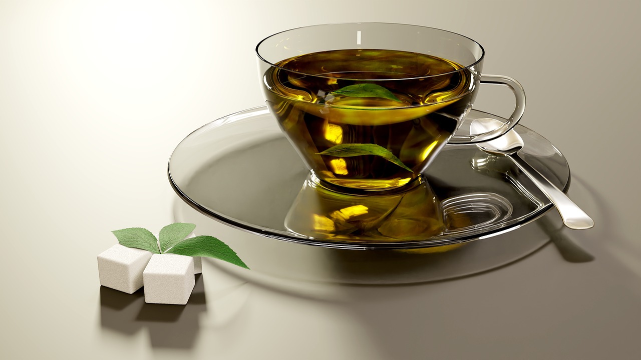 Tazza di tè verde fumante su un tavolo, simbolo di salute e benessere.