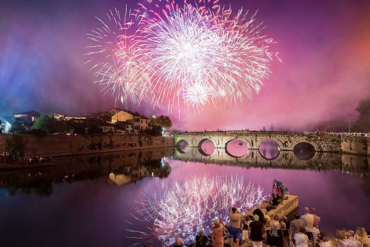 Panorama festivo di una città illuminata per Capodanno 2027, con fuochi d'artificio nel cielo.