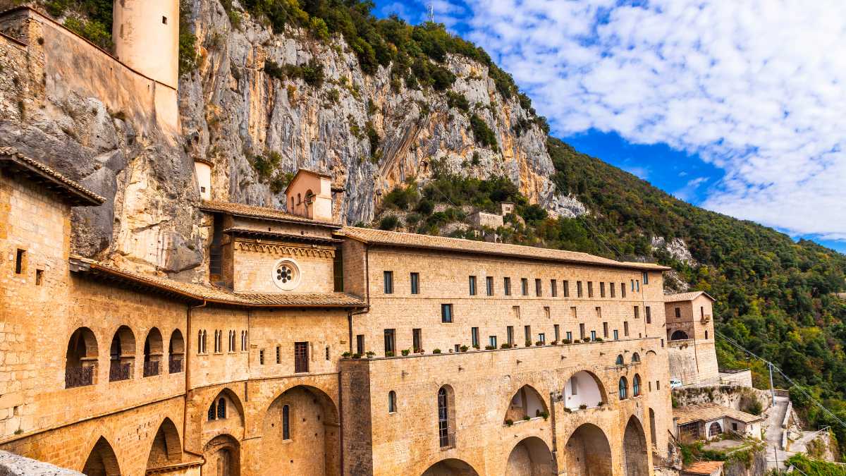 Monastero nascosto tra le montagne, circondato da un paesaggio mistico e suggestivo in Italia.