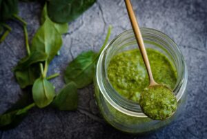 Barattolo di pesto con etichetta di avvertimento su effetti dannosi per cuore e fegato.