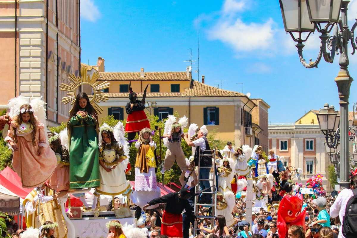 Festa patronale in Italia con colori vivaci, persone in costume e tradizioni locali.