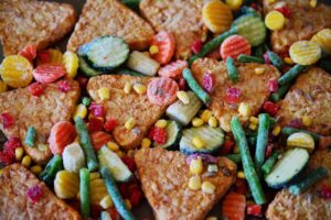 Immagine di diversi pacchi di surgelati con etichette di marche poco raccomandate al supermercato.